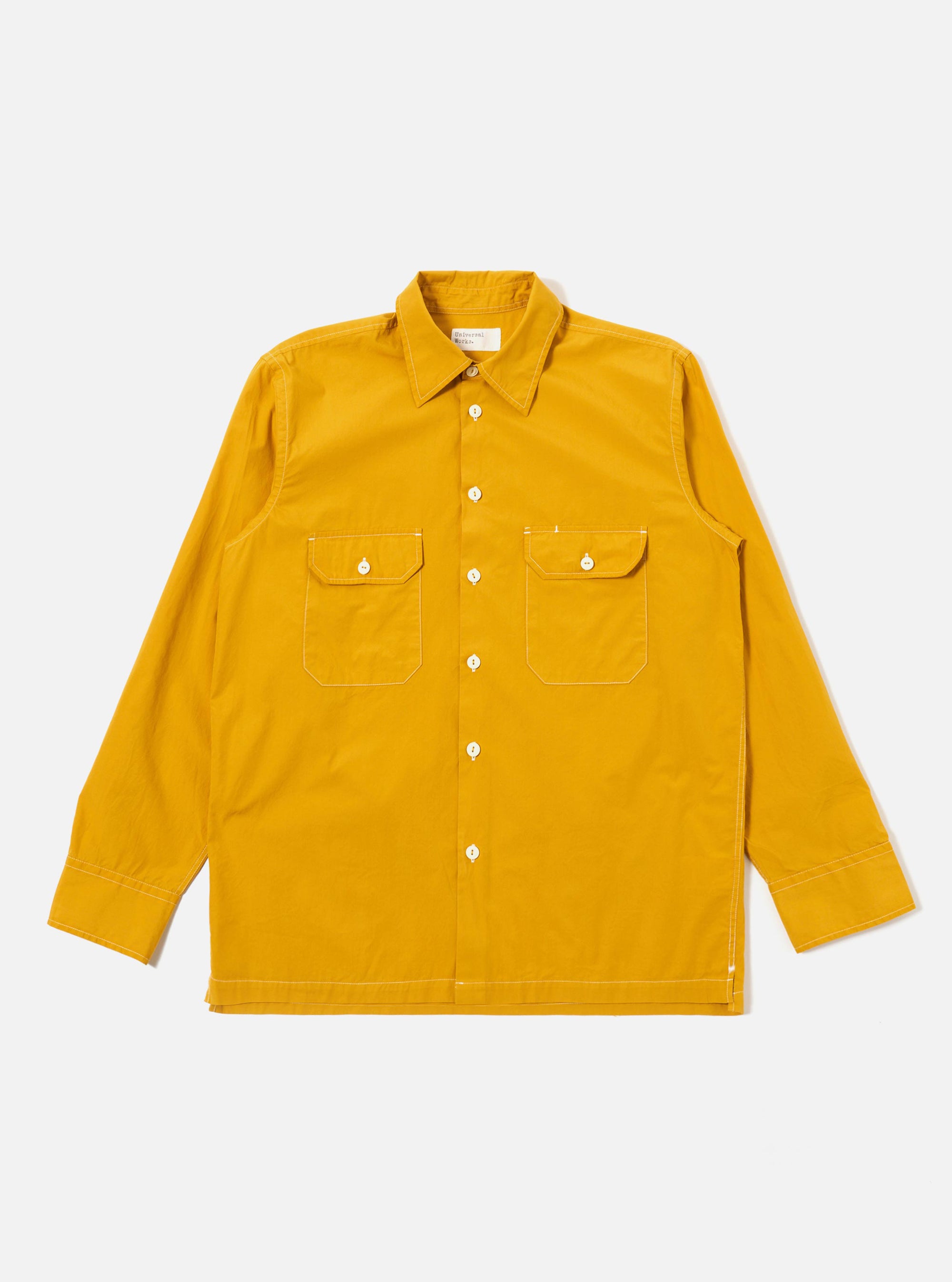 The Golden Brown Organic Fine Poplin CPO Shirt is shown as a flat lay against a white background. The shirt features two large button-down chest pockets, a classic pointed collar, and a central button-down closure. The fabric is a solid golden brown organic cotton poplin with a smooth finish.