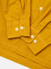 The Golden Brown Organic Fine Poplin CPO Shirt is shown from the back as a flat lay against a plain white background. The image highlights the shirt's straight hem, its loose and relaxed fit, and the smooth texture of the golden brown organic cotton poplin fabric.
