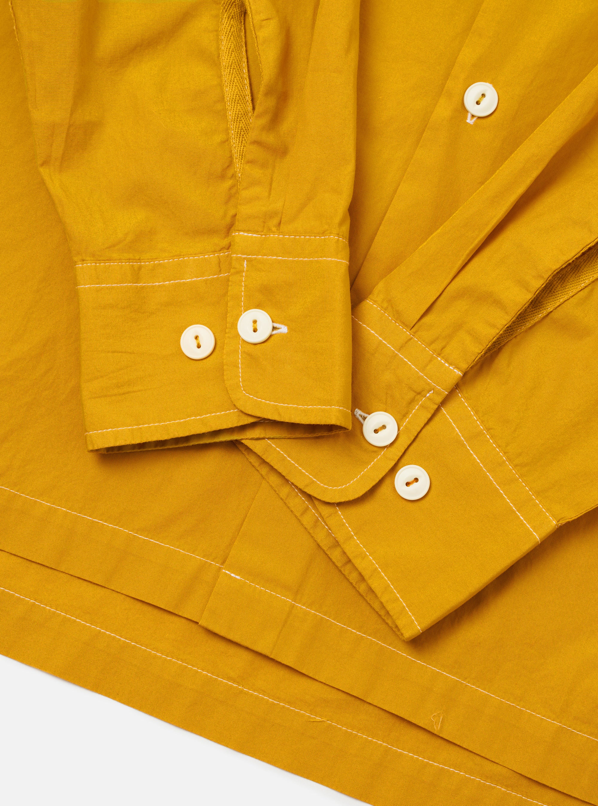 The Golden Brown Organic Fine Poplin CPO Shirt is shown from the back as a flat lay against a plain white background. The image highlights the shirt's straight hem, its loose and relaxed fit, and the smooth texture of the golden brown organic cotton poplin fabric.