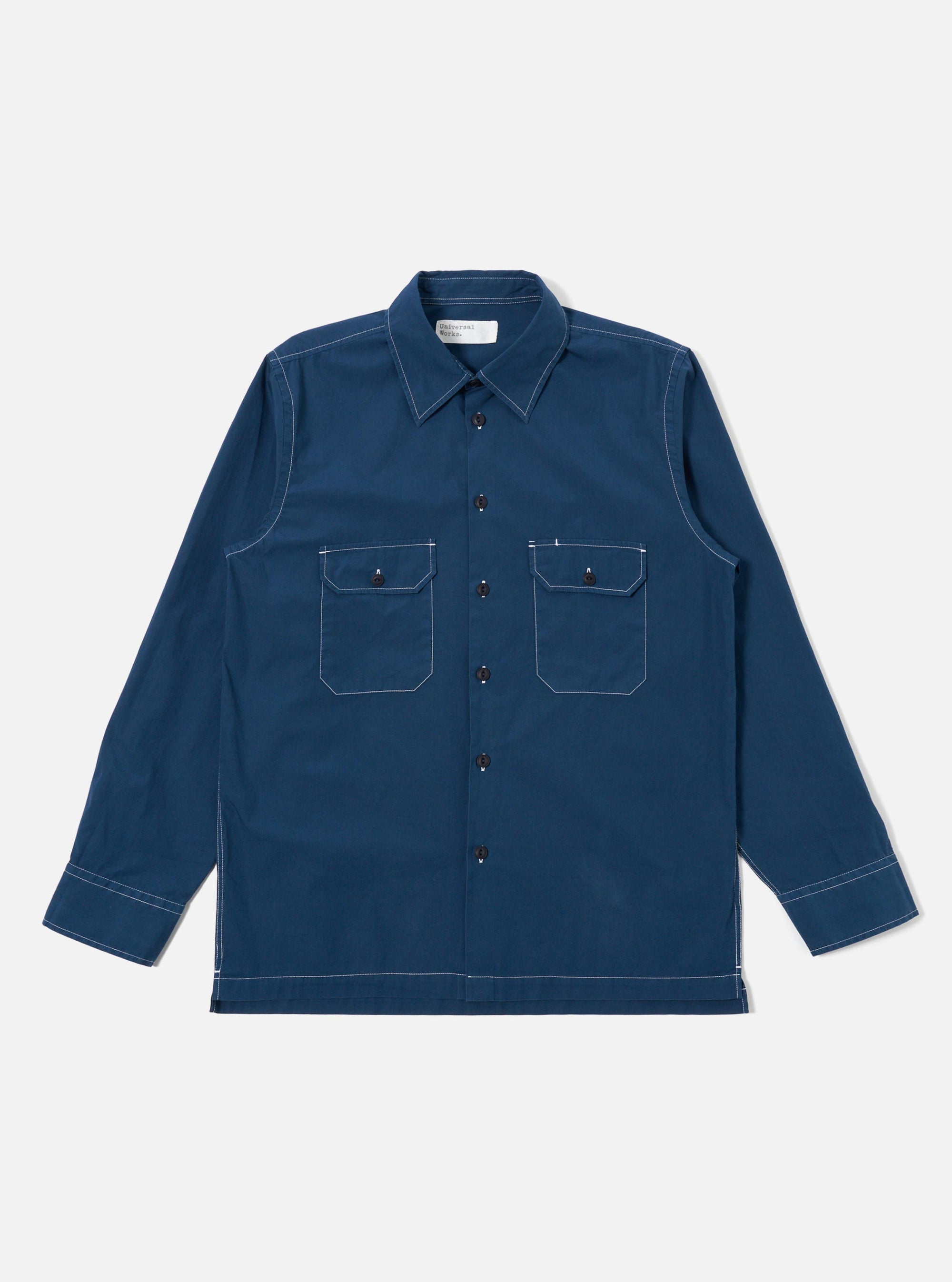 The Navy Organic Fine Poplin CPO Shirt is shown as a flat lay against a plain white background. The shirt features a loose fit, a two-piece collar, two buttoned chest pockets, and a straight hem. The dark navy organic cotton poplin fabric has a smooth, crisp finish.