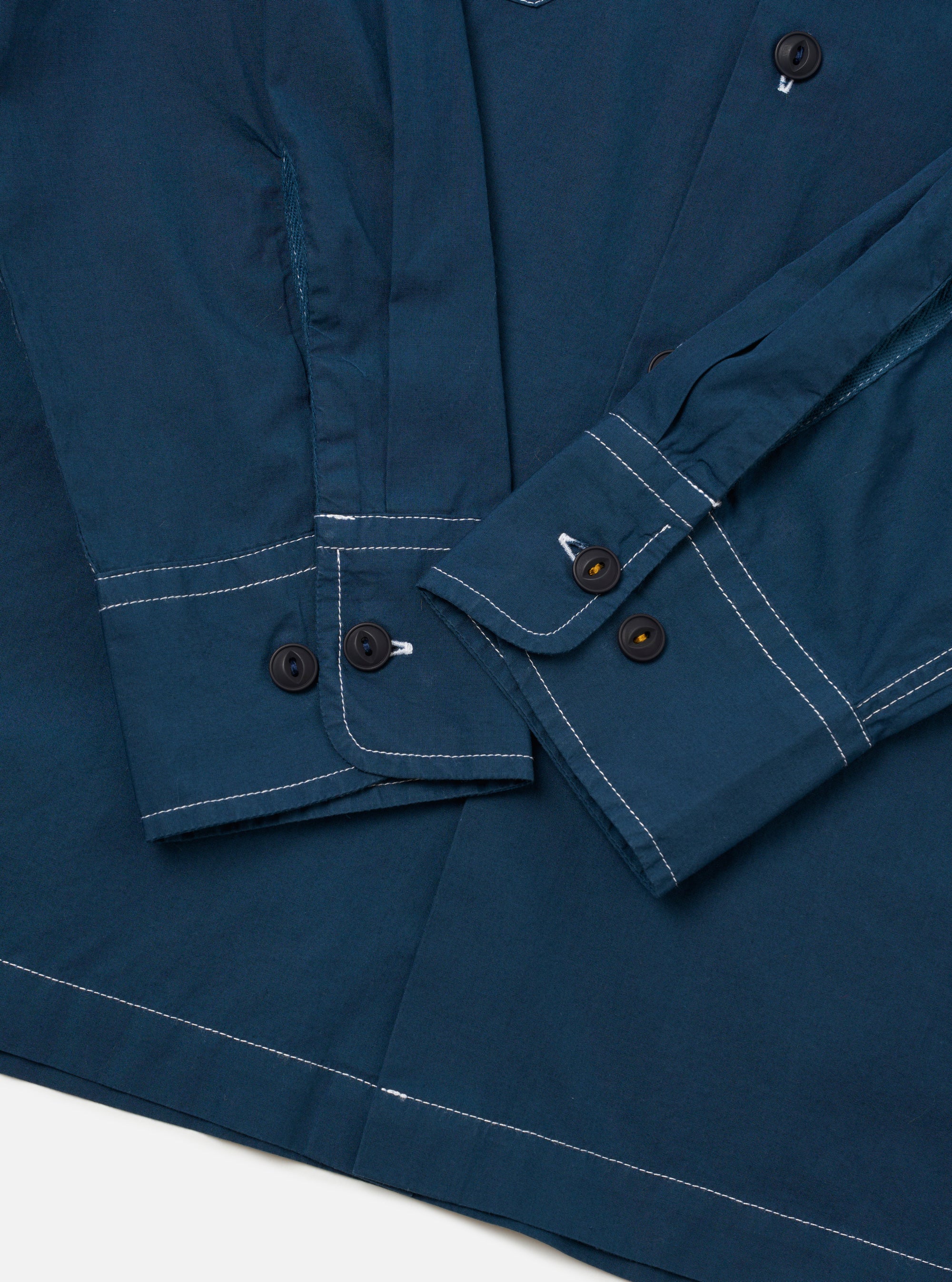 The Navy Organic Fine Poplin CPO Shirt is shown from the back as a flat lay against a plain white background. The image highlights the clean lines of the organic cotton poplin fabric, featuring a two-piece collar, a straight hem, and functional cuffs.
