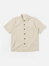 The Ecru Koko Cotlin S/S Fatigue Shirt is shown as a flat lay against a white background. The shirt features a button-down front, a classic collar, and two large patch pockets on the chest. The short-sleeved garment is made from a textured ecru-colored cotton-linen blend fabric.