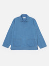The Washed Indigo Recycled Herringbone Smock Overshirt is shown as a flat lay against a white background. The overshirt features a wide, open-neck collar with a self-fabric loop for the top button and two large patch pockets at the waist. The indigo blue fabric displays a distinct herringbone weave, and the garment is shown partially unbuttoned to highlight its pullover style.