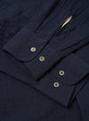 The Navy Seersucker Shirting Lucky Shirt is shown from the back as a flat lay against a plain white background. The image highlights the shirt's straight hem, simple back yoke, and the puckered texture of the navy blue seersucker fabric.