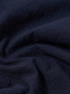 A close-up swatch image of the Navy Seersucker Shirting Road Shirt fabric highlights the deep navy blue color and the distinct puckered, wavy texture characteristic of seersucker. The material fills the frame, providing a detailed view of the lightweight cotton fabric's weave.