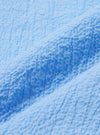 A close-up swatch image of the Sky Blue Seersucker Shirting Road Shirt fabric highlights the light blue and white striped pattern and the characteristic puckered texture of the seersucker weave. The fabric fills the frame, providing a detailed view of the material's construction.