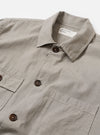 The Grey Izumi Cotton Dockside is shown from the back as a flat lay against a plain white background. The garment features a straight hem, a simple yoke across the shoulders, and a relaxed fit. The fabric has a subtle textured appearance in a solid grey color.