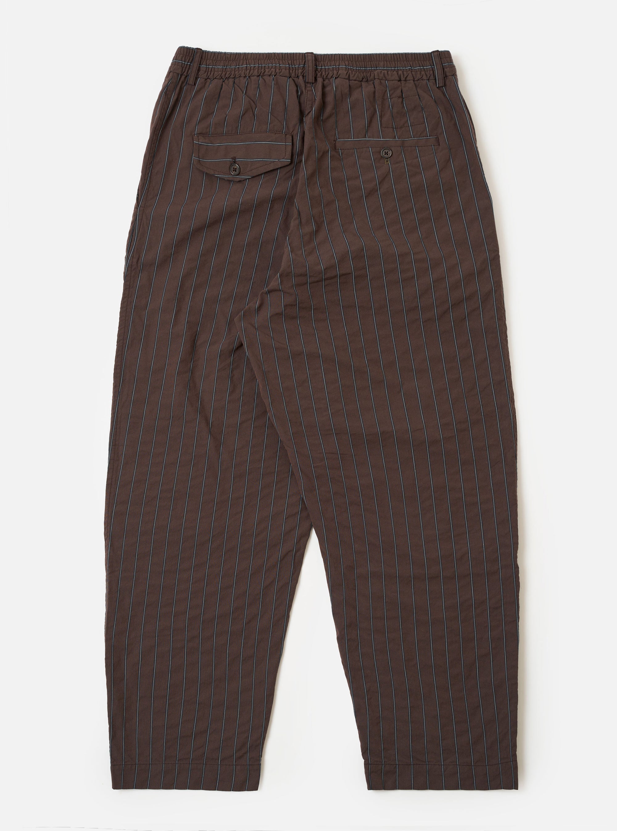 The Brown Chester Stripe Oxford Pant is shown from the back as a flat lay against a plain white background. The trousers feature a vertical brown stripe pattern throughout and an elasticated waistband. A single rear patch pocket is visible on the right side.