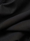 The Black Valencia Cotton Two Button Jacket is shown in a detail view as a flat lay against a plain white background. The image highlights the textured weave of the black cotton-blend fabric and the construction of the lower front patch pocket.