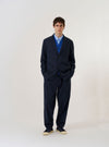 The Navy Valencia Cotton Two Button Jacket is shown as a flat lay against a white background. The jacket features a classic notched lapel, a two-button front closure, and two large patch pockets at the waist. The dark navy fabric has a smooth, refined finish.