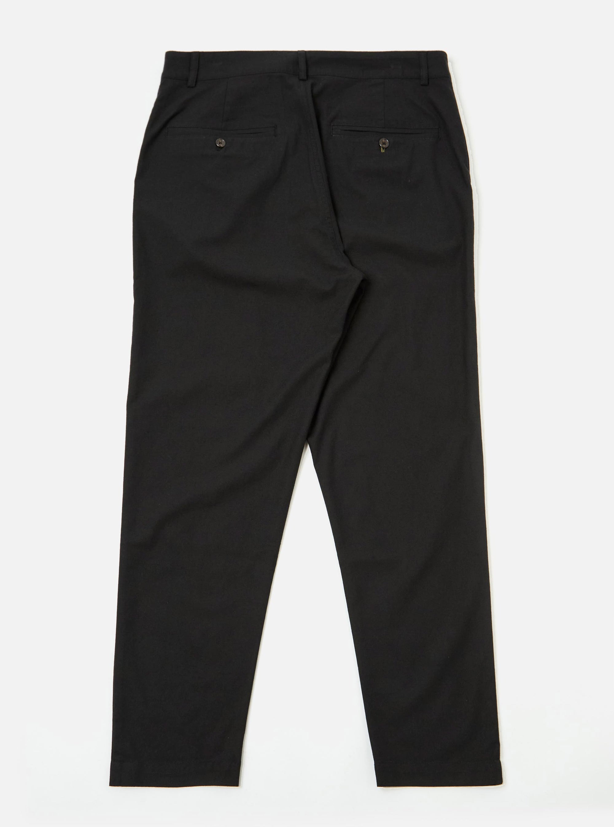 The Black Valencia Cotton Military Chino is shown from a rear angle as a flat lay against a plain white background. The image highlights the two back welt pockets with button-down flaps and the straight-leg construction. The black cotton-blend fabric has a subtle textured finish.