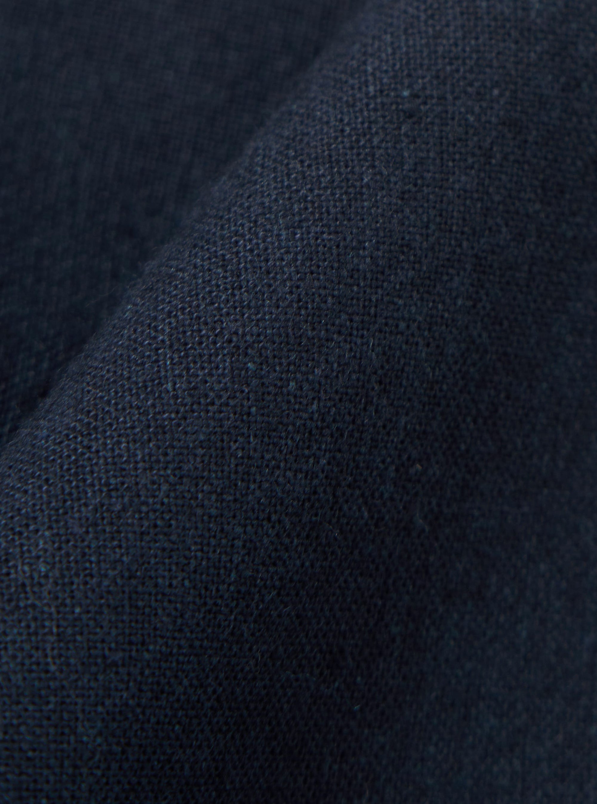 A close-up fabric swatch of the Navy Valencia Cotton Military Chino is shown, highlighting the dark navy blue color and the textured, woven character of the cotton-blend fabric.