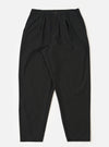 The Black Valencia Cotton Pleated Track Pant is shown as a flat lay against a white background. The trousers feature a loose, tapered leg with a single pleat at the front and an elasticated drawstring waistband. The fabric is a smooth black cotton blend.