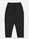 The Black Valencia Cotton Pleated Track Pant is shown from the back as a flat lay against a plain white background. The image highlights the elasticated waistband and the two rear pockets: one featuring a buttoned flap and the other a button jetted design. The black fabric has a clean, fine plain weave texture.