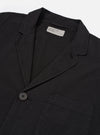 The Black Merida Seersucker Three Button Jacket is shown from the back as a flat lay against a plain white background. The image highlights the jacket's unstructured design, a central vertical seam, and the textured, puckered finish of the black seersucker fabric.