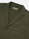 The Olive Merida Seersucker Three Button Jacket is shown as a flat lay against a white background. The jacket features a three-button front closure, a notch lapel, and two large patch pockets at the hips. The olive green fabric has a distinct puckered seersucker texture throughout.
