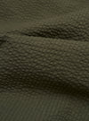 A close-up swatch image of the Olive Merida Seersucker Three Button Jacket displays the fabric's distinct puckered texture in a solid olive green color. The weave features alternating smooth and raised rows characteristic of seersucker.