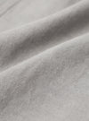 A close-up fabric swatch of the Grey Izumi Cotton Hi Water Trouser highlights the material's color and texture. The image shows a grey cotton fabric with a subtle, fine-grained weave.