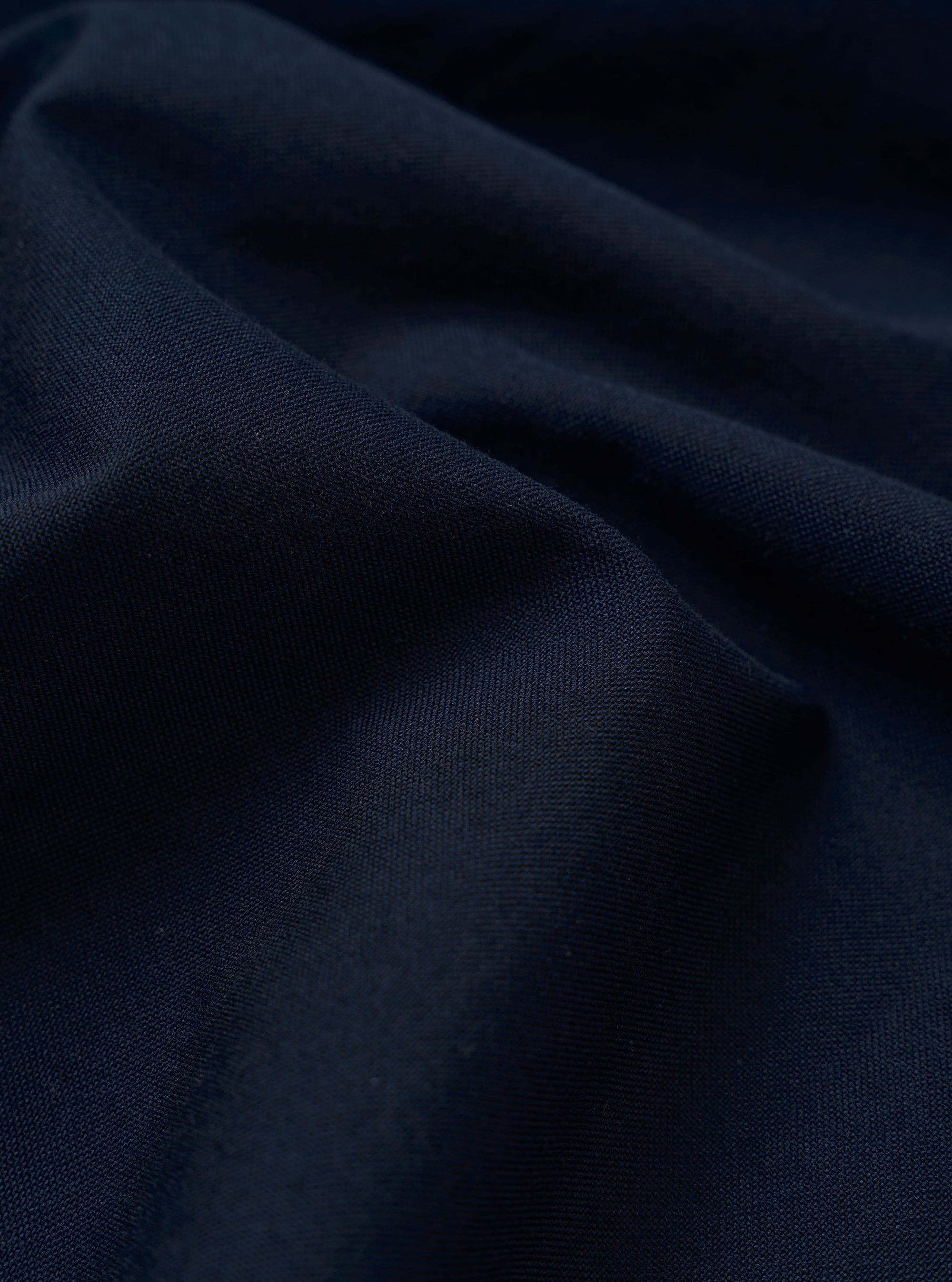 The Navy Classic Oxford Tropicana Shirt is presented as a flat lay against a plain white background. The shirt features a classic button-down front, a pointed collar, and a single patch pocket on the left chest. The deep navy blue fabric shows a visible Oxford weave texture.