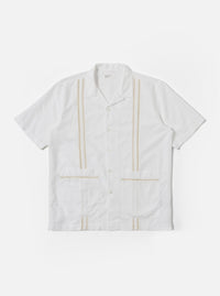 The White Classic Oxford Tropicana Shirt is shown as a flat lay against a white background. The shirt features a one-piece open collar, short loose sleeves, and two large patch pockets located at the lower front hip area. It has a center-front button closure and is made from a textured white Oxford cotton fabric.