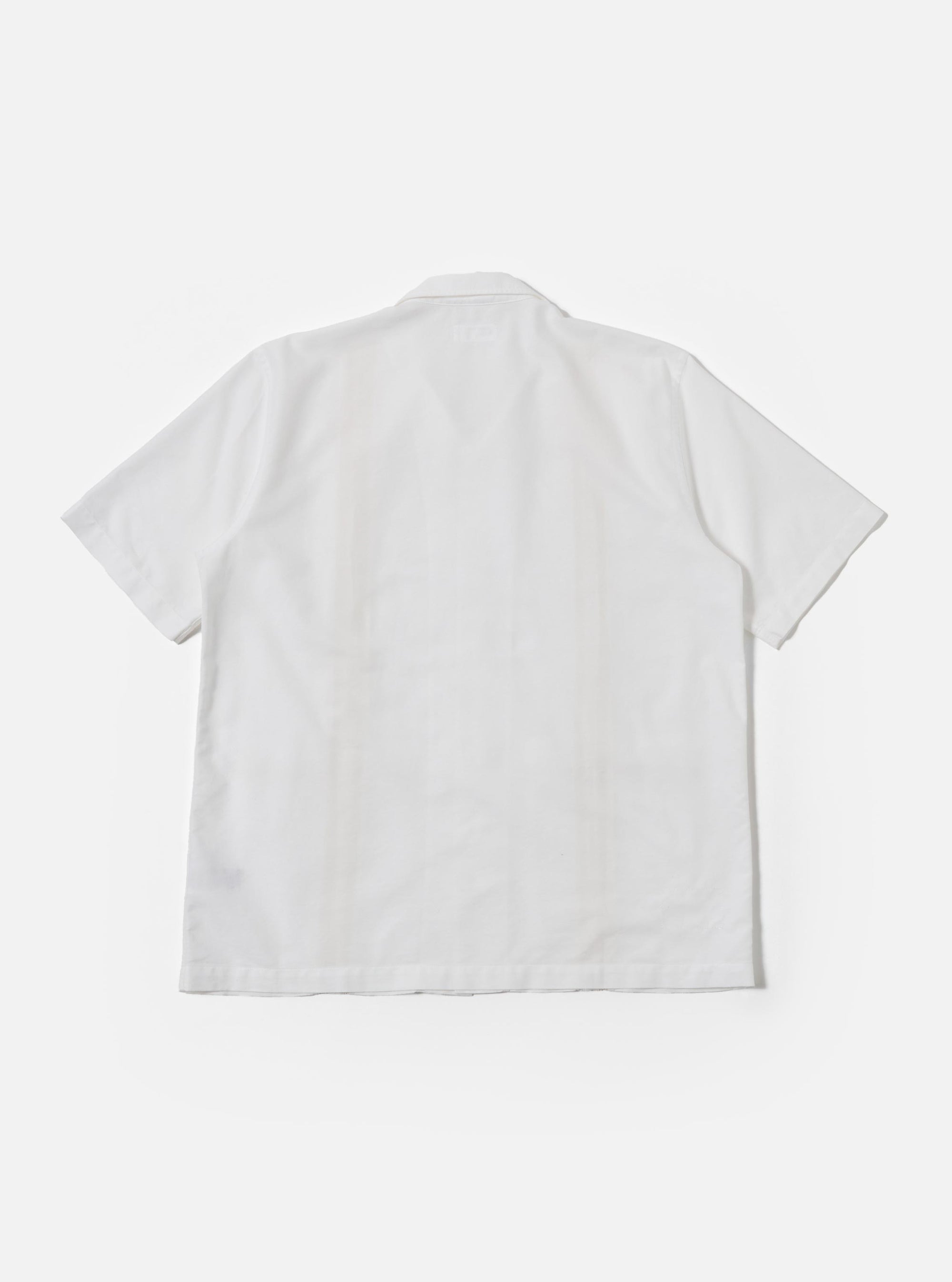 The White Classic Oxford Tropicana Shirt is shown as a flat lay against a white background. The shirt features an open convertible collar, a full-length button placket with five buttons, and two large chest patch pockets. It has short raglan sleeves and a straight hem with small side slits. The fabric is a crisp white Oxford cotton.