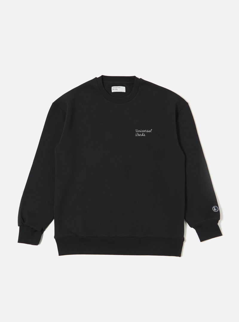 The Black Recycled Cotton Blend Jersey Loose Sweatshirt is shown as a flat lay against a plain white background. The sweatshirt features a classic crew neckline, long sleeves with ribbed cuffs, and a ribbed hem. The garment has a relaxed, loose fit and is made from a smooth black jersey fabric.