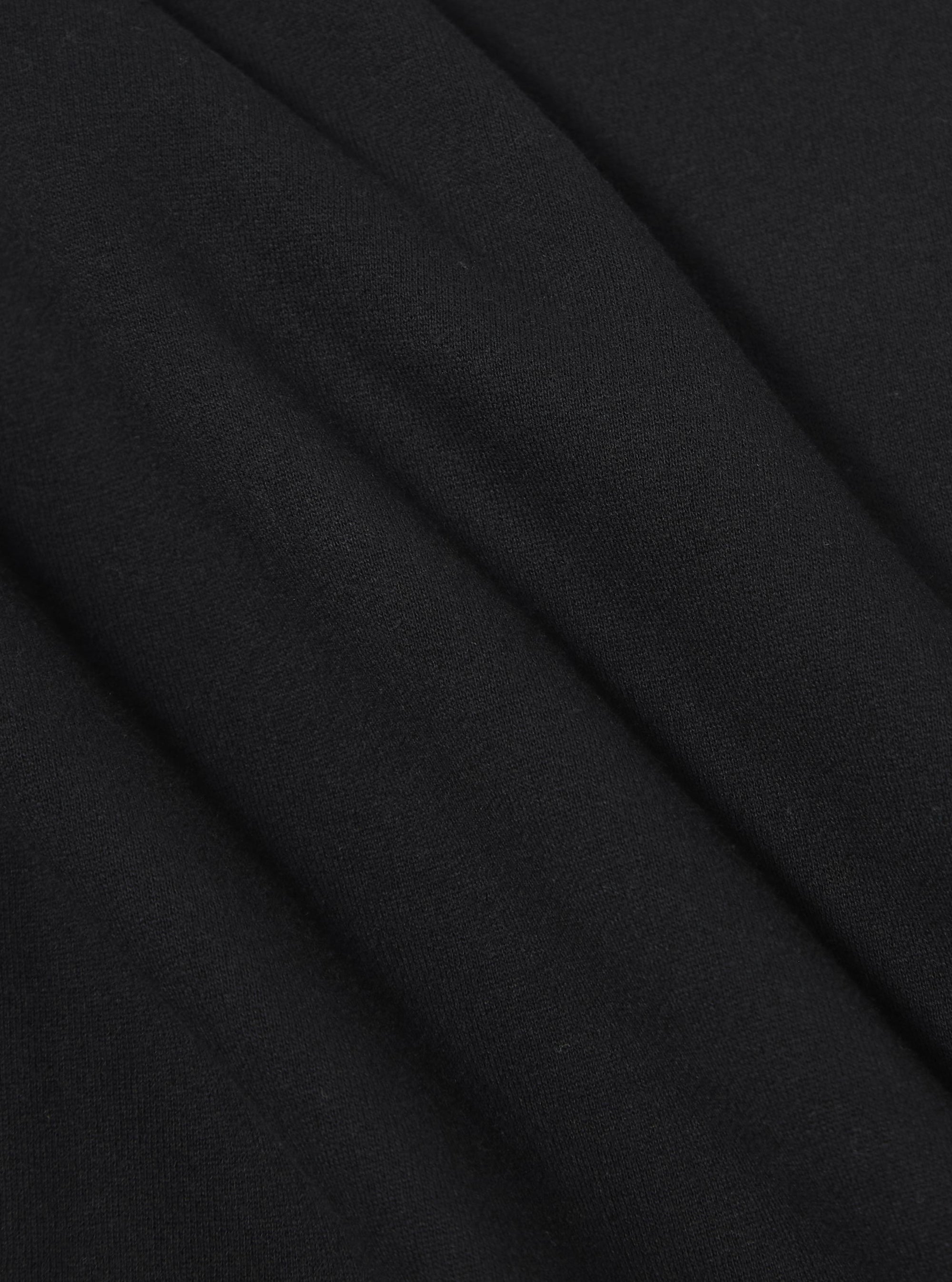A close-up fabric swatch of the Black Recycled Cotton Blend Jersey Loose Sweatshirt displays the solid black color and soft, knitted texture of the recycled cotton blend material. The fabric fills the entire frame, providing a detailed view of the garment's weave.