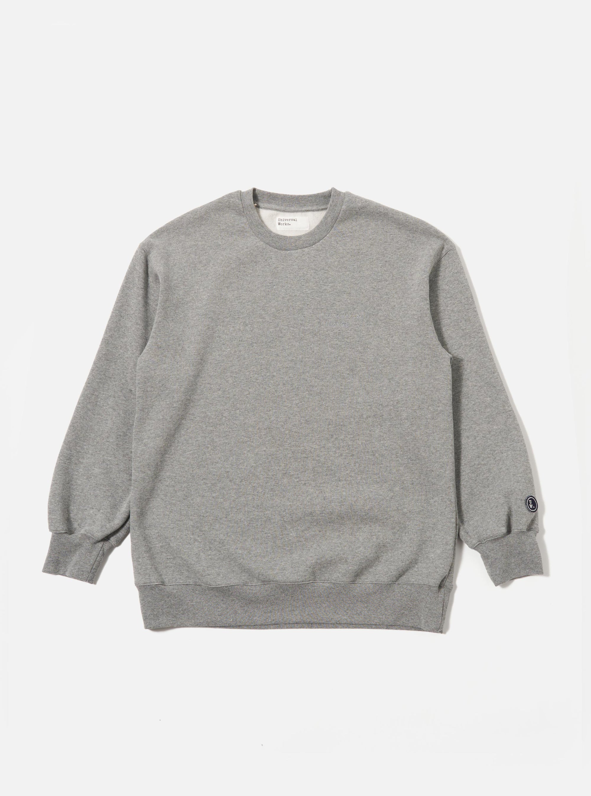 The Grey Marl Recycled Cotton Blend Jersey Loose Sweatshirt is shown as a flat lay against a plain white background. The sweatshirt features a crew neckline, long sleeves with dropped shoulders, and ribbed trim at the collar, cuffs, and hem. The fabric has a light grey marl texture.