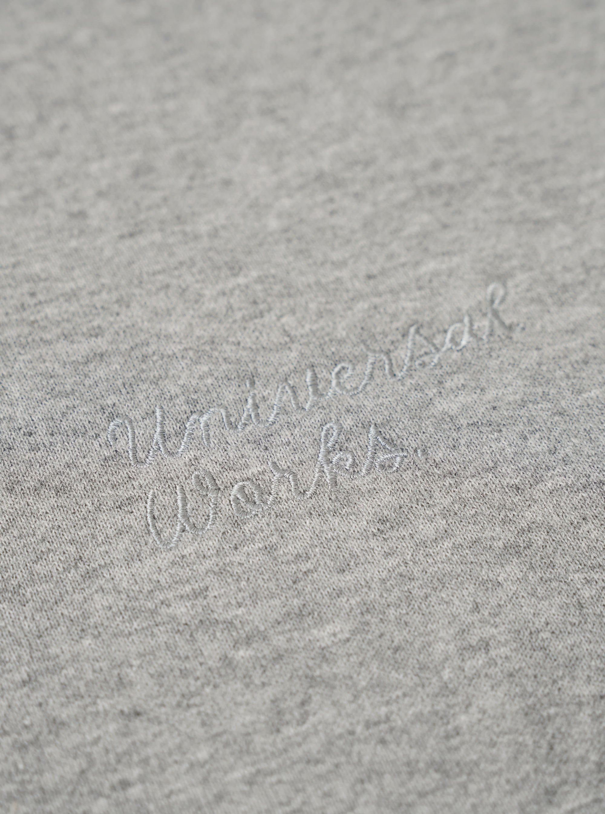 The Grey Marl Recycled Cotton Blend Jersey Loose Sweatshirt is shown from the back as a flat lay against a plain white background. The image highlights the sweatshirt's relaxed, loose fit, its simple crew neck, and the ribbed cuffs and hem. The fabric has a classic grey marl texture.