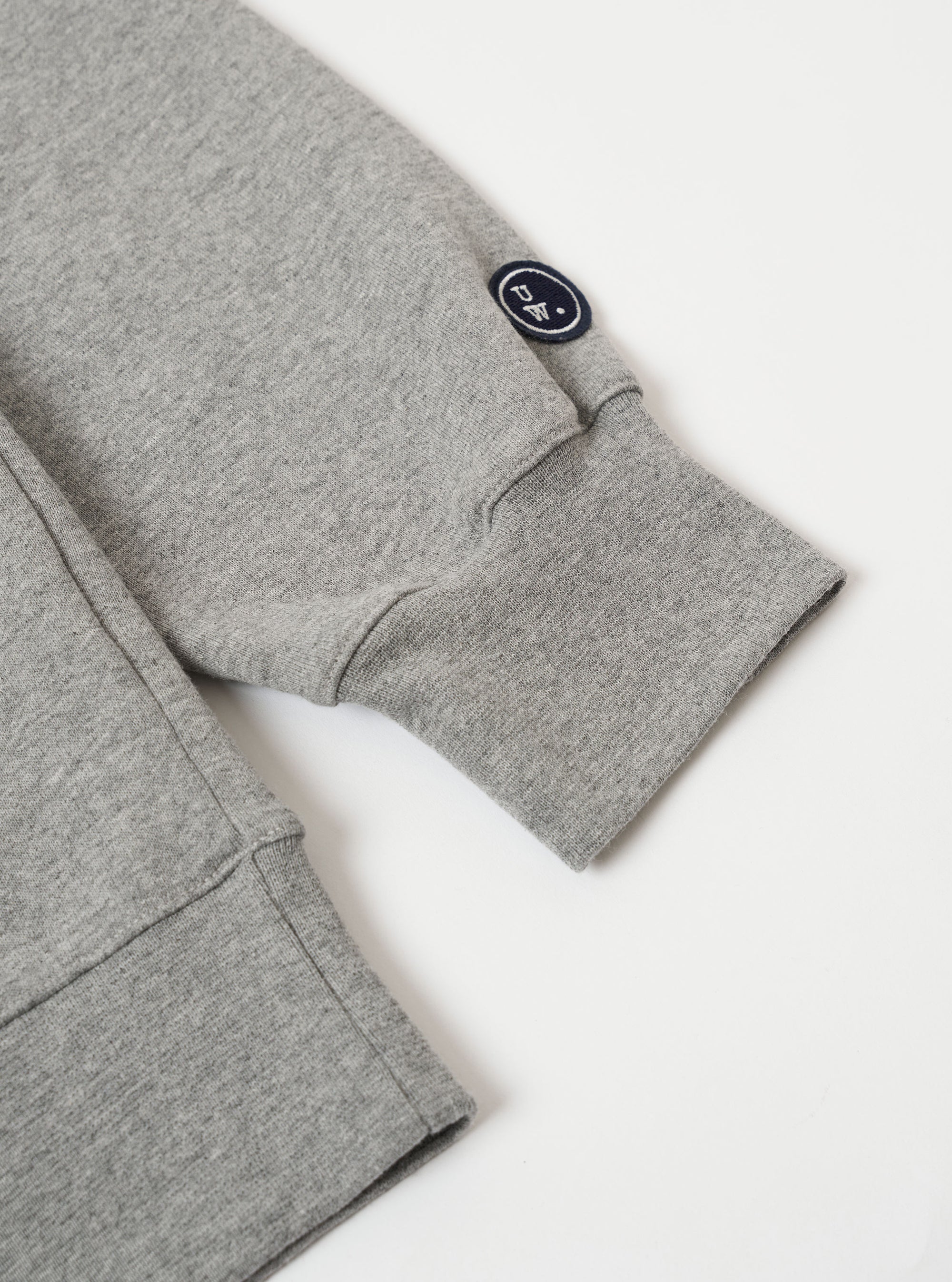 The Grey Marl Recycled Cotton Blend Jersey Loose Sweatshirt is shown from the back as a flat lay against a plain white background. The image highlights the sweatshirt's relaxed, loose fit, its ribbed crew neck, and the elasticated ribbed hem and cuffs. The fabric has a soft, textured grey marl appearance.