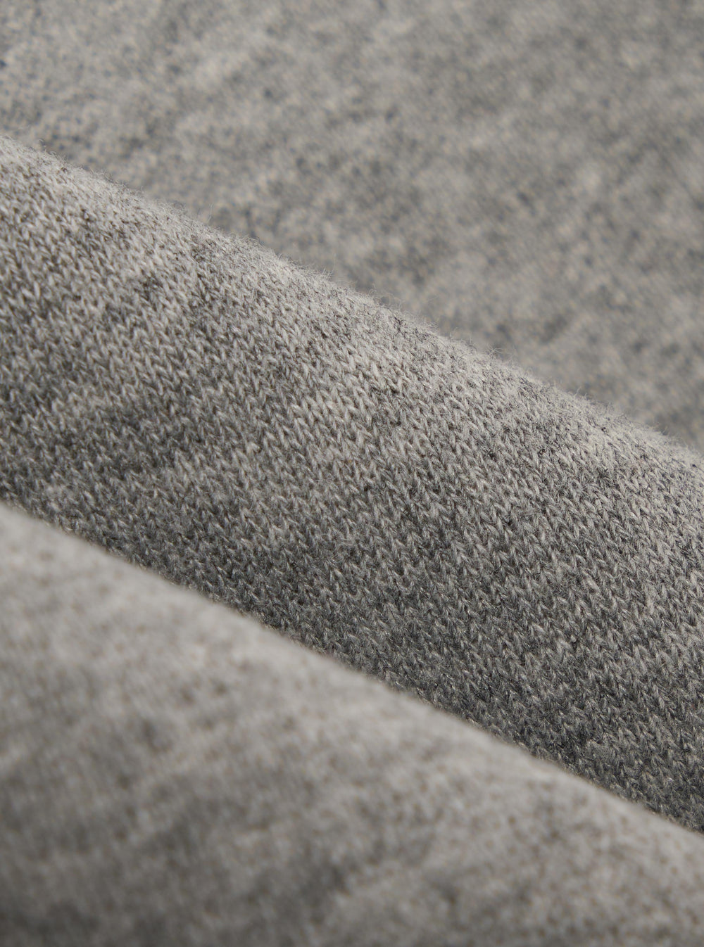 A close-up fabric swatch of the Grey Marl Recycled Cotton Blend Jersey Loose Sweatshirt displays a light grey heathered texture. The image focuses on the soft, knit quality of the recycled cotton blend material, which fills the entire frame.