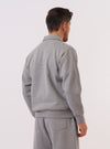 A model wears the Grey Marl Recycled Cotton Blend Jersey Tyler Jacket, shown from the back against a plain white background. The jacket features a relaxed fit with a straight hem, a simple neckline, and visible seam detailing across the shoulders and down the center back. The grey marl fabric has a soft, heathered texture.