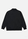 The Black Recycled Cotton Blend Jersey Tyler Jacket is shown from the back as a flat lay against a plain white background. The image highlights the jacket's simple construction, featuring a self-fabric collar and ribbed detailing at the cuffs and hem. The black jersey fabric appears smooth and consistent throughout the rear panel.