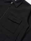 The Black Recycled Cotton Blend Jersey Tyler Jacket is shown from the back as a flat lay against a plain white background. The image highlights the garment's relaxed fit, the ribbed texture of the cuffs and hem, and the smooth finish of the black jersey fabric. A small embroidered patch is visible on the upper sleeve.