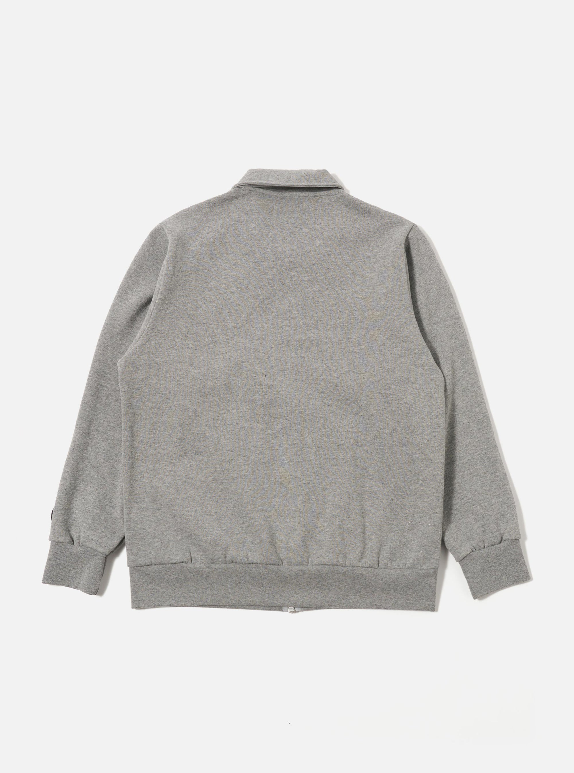 The Grey Marl Recycled Cotton Blend Jersey Tyler Jacket is shown from the back as a flat lay against a plain white background. The image highlights the jacket's simple construction, featuring a straight back panel, a structured collar, and ribbed detailing at the cuffs and hem. The grey marl fabric has a soft, heathered appearance.