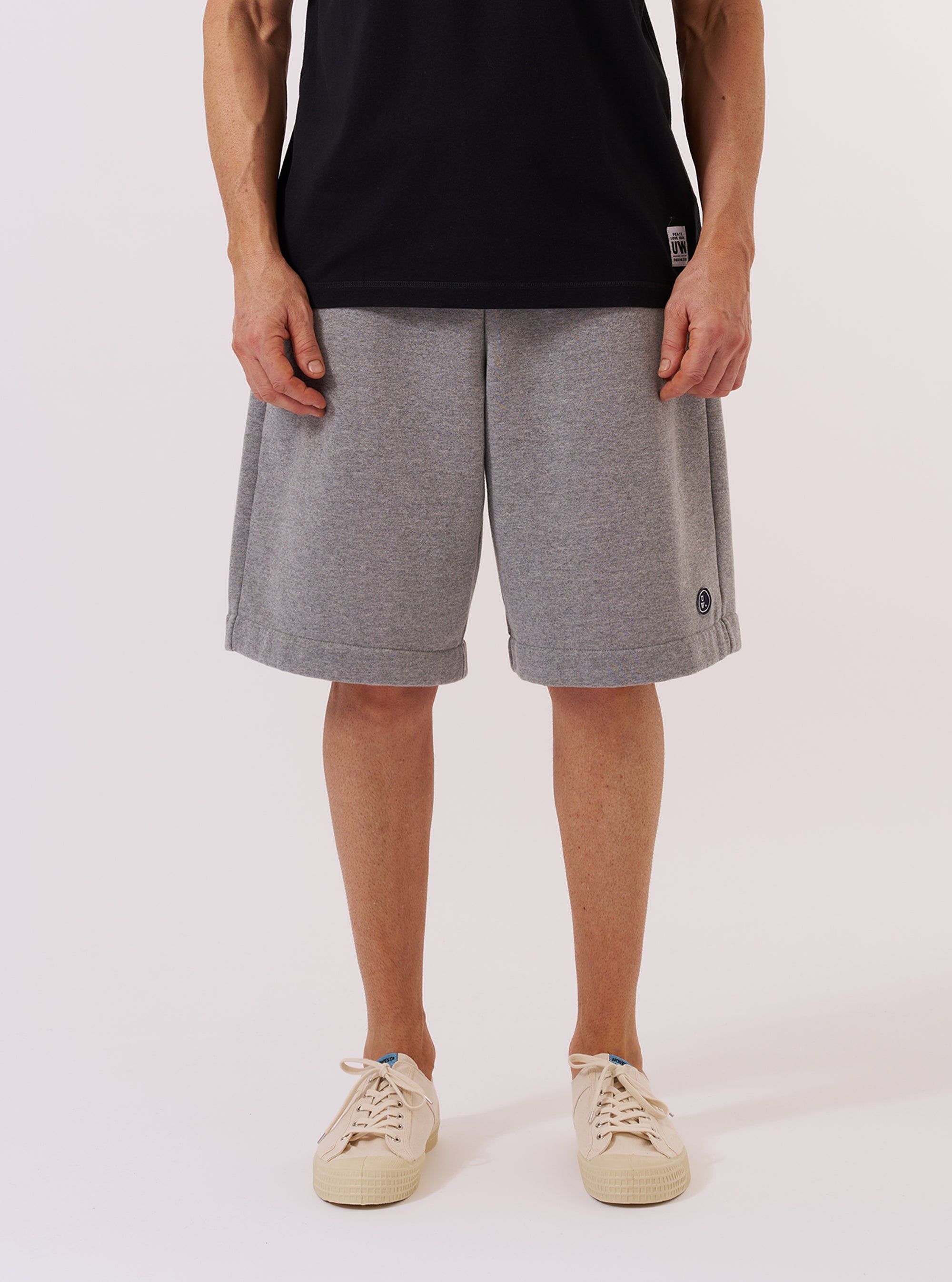 A model wears the Grey Marl Recycled Cotton Blend Jersey Vacation Short against a plain white background. The shorts feature a relaxed fit, an elasticated waistband with a tonal drawstring, and two side pockets. The grey marl fabric has a soft, heathered texture. The model is shown from the waist down, showcasing the garment's casual design.