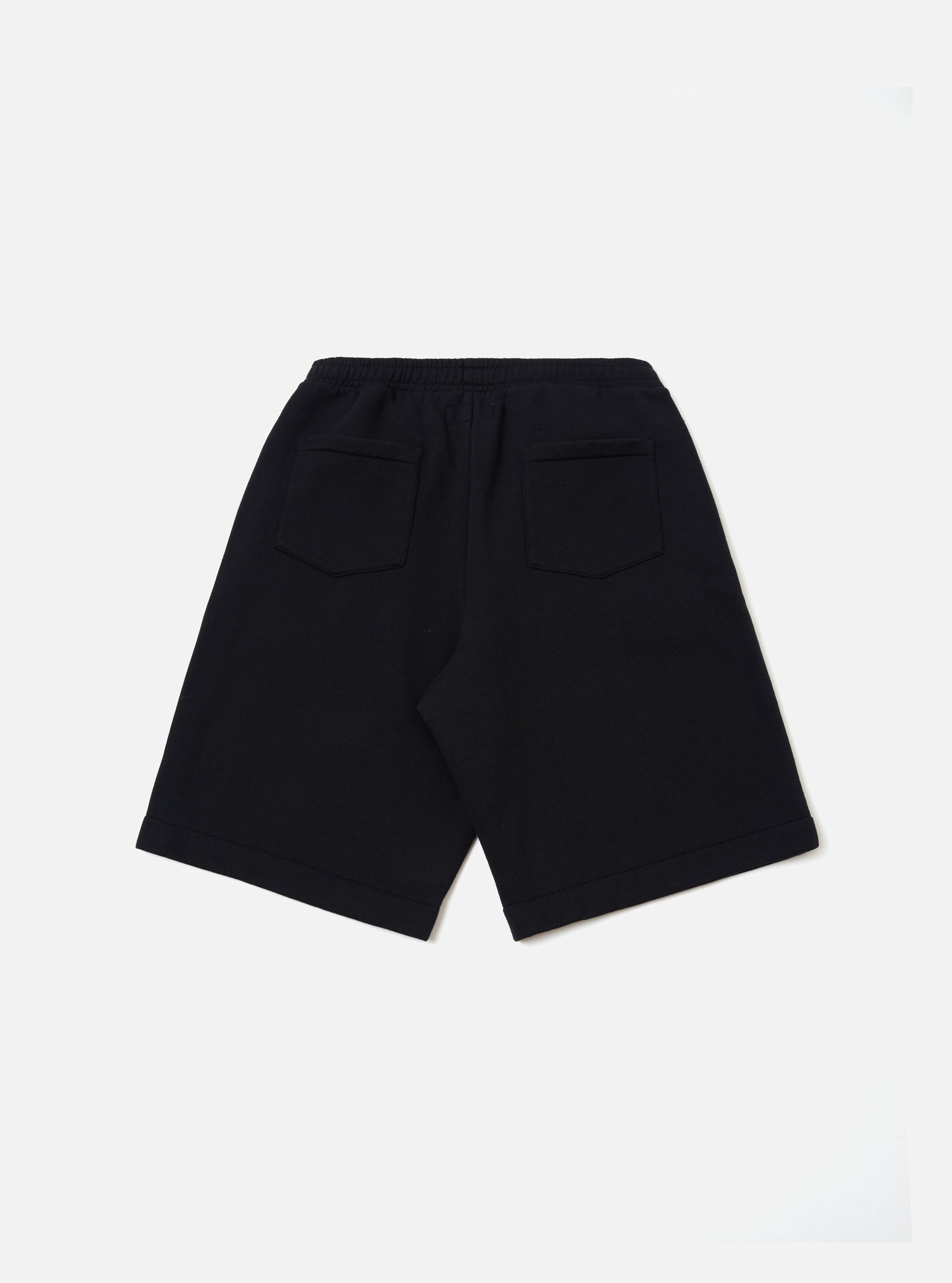 The Black Recycled Cotton Blend Jersey Vacation Short is shown from a rear angle as a flat lay against a plain white background. The back of the shorts features two patch pockets and an elasticated waistband. The black jersey fabric has a soft, textured appearance.