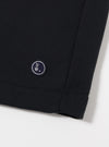The Black Recycled Cotton Blend Jersey Vacation Short is shown from the back as a flat lay against a plain white background. The image highlights the elasticated waistband and a single rear patch pocket. The black jersey fabric has a soft, matte appearance with clean stitching along the hem and pocket.