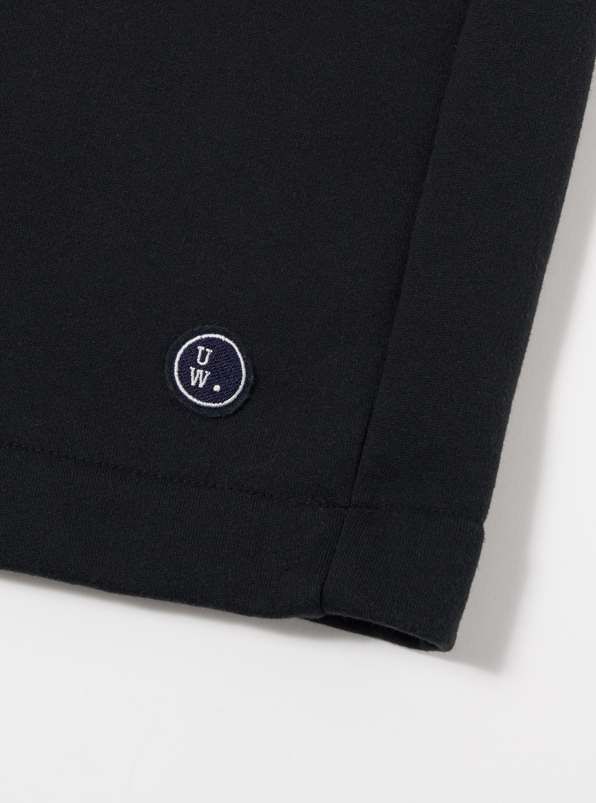 The Black Recycled Cotton Blend Jersey Vacation Short is shown from the back as a flat lay against a plain white background. The image highlights the elasticated waistband and a single rear patch pocket. The black jersey fabric has a soft, matte appearance with clean stitching along the hem and pocket.