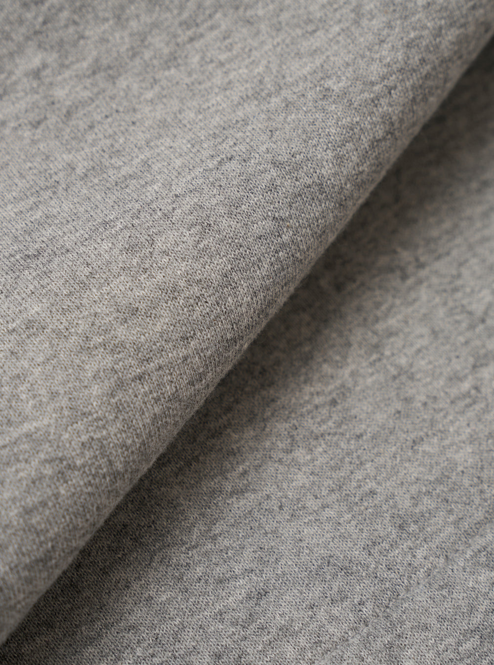 A close-up fabric swatch of the Grey Marl Recycled Cotton Blend Jersey Vacation Short highlights the soft, knitted texture of the material. The fabric features a classic heathered grey marl pattern, showing a blend of light and dark grey tones.