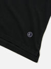 The Black Piquet Vacation Polo is shown as a flat lay against a plain white background. The image provides a close-up view of the back of the garment, highlighting the textured black piquet cotton fabric, a simple straight hem, and a one-piece collar.