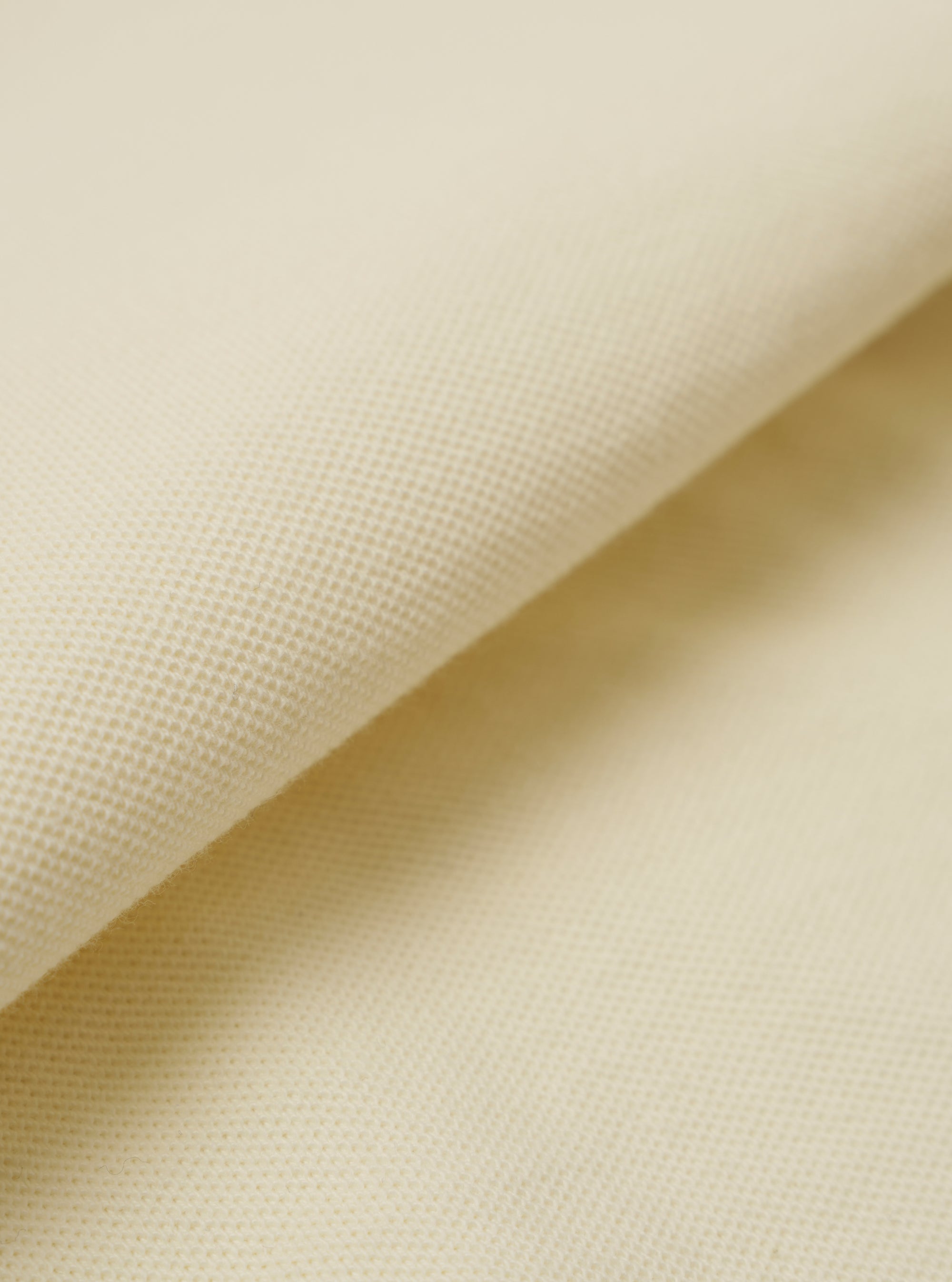 A close-up swatch image of the Ecru Piquet Vacation Polo fabric highlights the intricate honey-comb piquet texture. The fabric is a solid ecru color, and the image focuses entirely on the material's knit pattern and soft appearance.