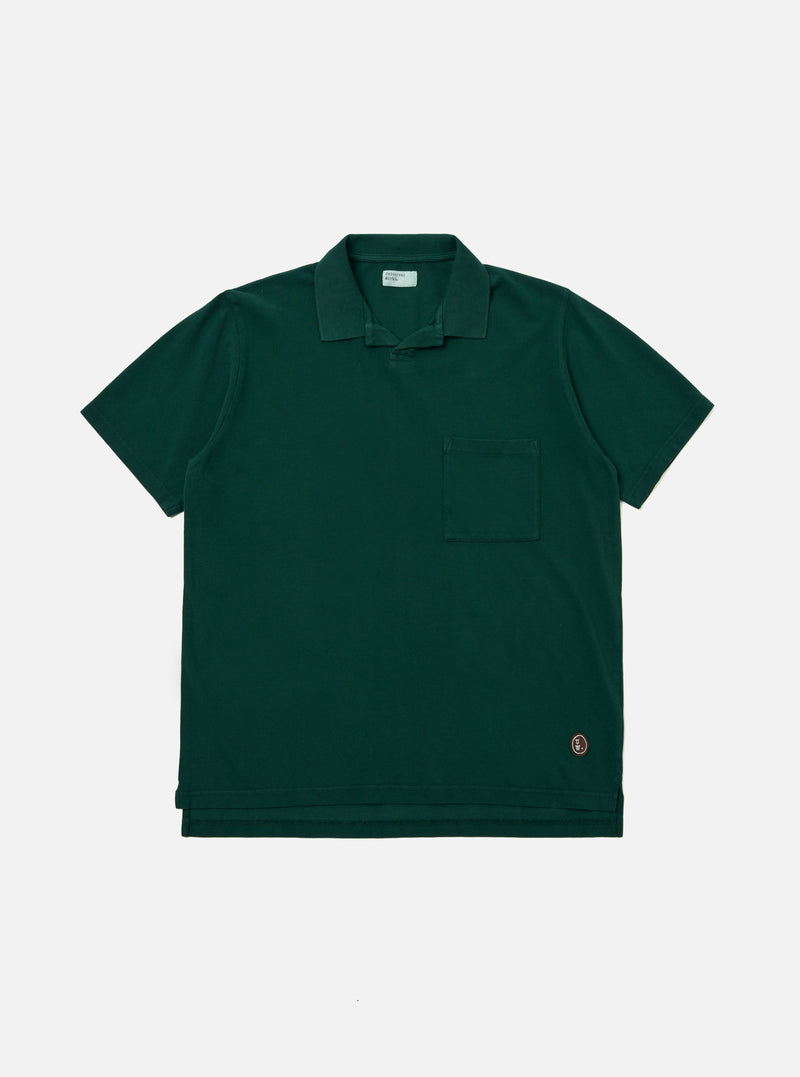 The Green Piquet Vacation Polo is displayed as a flat lay against a plain white background. The shirt features a one-piece collar, a single patch chest pocket, and a short-sleeve construction. The green piquet fabric has a distinct, textured honeycomb-like weave.
