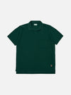 The Green Piquet Vacation Polo is displayed as a flat lay against a plain white background. The shirt features a one-piece collar, a single patch chest pocket, and a short-sleeve construction. The green piquet fabric has a distinct, textured honeycomb-like weave.