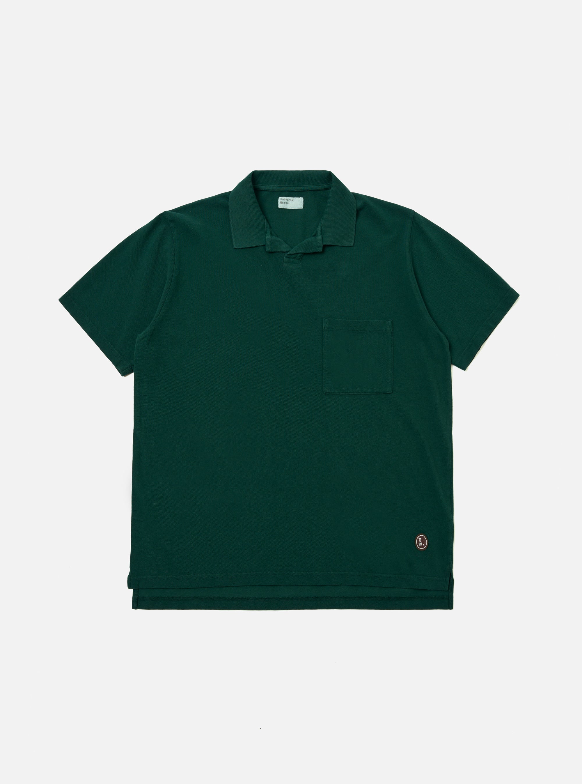 The Green Piquet Vacation Polo is displayed as a flat lay against a plain white background. The shirt features a one-piece collar, a single patch chest pocket, and a short-sleeve construction. The green piquet fabric has a distinct, textured honeycomb-like weave.