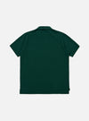 The Green Piquet Vacation Polo is shown from the back as a flat lay against a plain white background. The image highlights the garment's textured green piquet fabric, straight hem, and clean back panel construction.