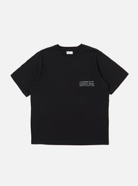 The Black Organic Jersey Print Pocket Tee is displayed as a flat lay against a plain white background. The T-shirt features a classic crew neckline, short sleeves, and a single patch pocket on the left chest area featuring a graphic print. The garment is made from a solid black organic cotton jersey fabric.