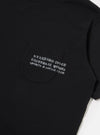The Black Organic Jersey Print Pocket Tee is shown from a rear angle as a flat lay against a plain white background. The image highlights the clean construction of the shoulders and the smooth finish of the black organic cotton fabric.
