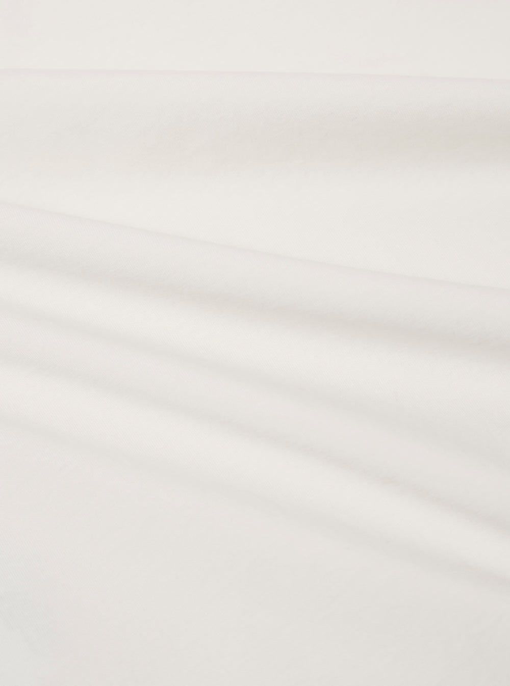 A close-up fabric swatch of the Ecru Organic Jersey Print Pocket Tee highlights the off-white ecru color and the fine, soft knit texture of the organic cotton jersey fabric. The material fills the frame, providing a detailed view of the textile's surface.