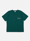 The Olive Organic Jersey Print Pocket Tee is shown as a flat lay against a plain white background. The t-shirt features a crew neckline, short sleeves, and a single patch pocket on the left chest. The pocket is detailed with a small graphic print in a contrasting color. The garment is made from a smooth olive green organic cotton jersey.